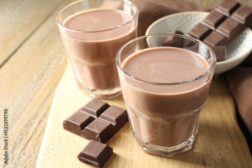 Wallpaper Mural Tasty chocolate milk in glasses and pieces on wooden table, closeup Torontodigital.ca