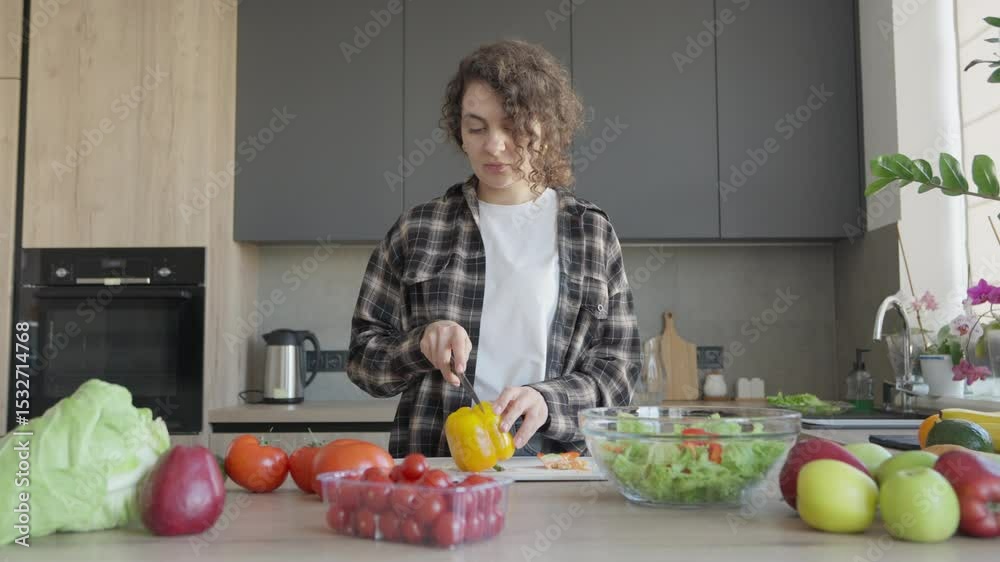 Woman Cleaning, Slicing Yellow Bell Pepper In Bright Kitchen With Fresh Produce Woman Cleaning, Slicing Yellow Bell Pepper In Bright Kitchen With Fresh Produce