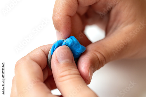 Close-up of child folding blue and purple modeling clay. Summer creative activity for children promoting imagination and development. Soft texture. Selective focus.