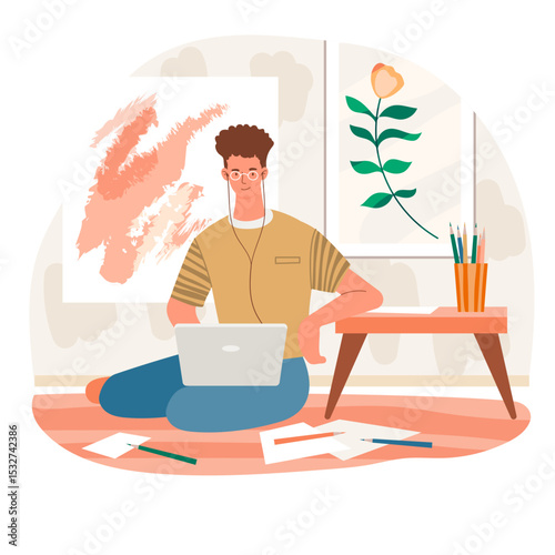 Man working on laptop at home surrounded by art and creative supplies