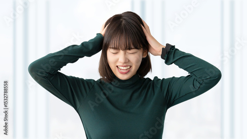 頭を抱えて困る若い女性・ビジネスウーマン