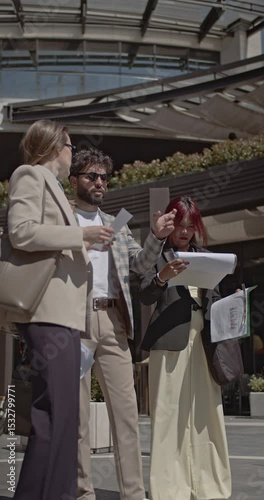 Wallpaper Mural Three business professionals review paperwork and discuss strategy outdoors on a sunny day. Urban business discussion, teamwork, and collaboration. Torontodigital.ca