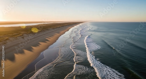 Wide Aerial View of Serene Ocean Waves Rolling on Sandy Beach at Sunset