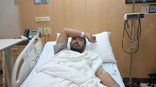 Asian man is sick and is being treated at the hospital,Waiting for the doctor to give intravenous medication,A nurse came to take my temperature and measure my blood pressure.