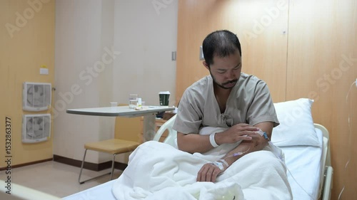 Asian man is sick and is being treated at the hospital,Waiting for the doctor to give intravenous medication,A nurse came to take my temperature and measure my blood pressure.