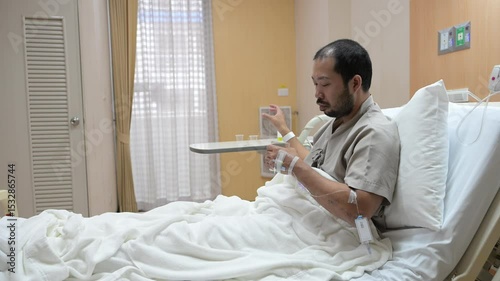 Asian man is sick and is being treated at the hospital,Waiting for the doctor to give intravenous medication,A nurse came to take my temperature and measure my blood pressure.