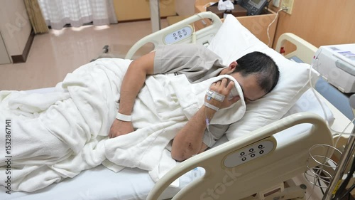 Asian man is sick and is being treated at the hospital,Waiting for the doctor to give intravenous medication,A nurse came to take my temperature and measure my blood pressure.