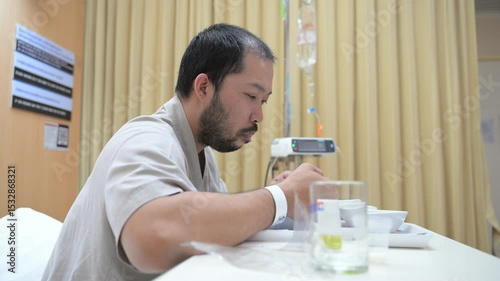 Asian man is sick and is being treated at the hospital,Waiting for the doctor to give intravenous medication,A nurse came to take my temperature and measure my blood pressure.