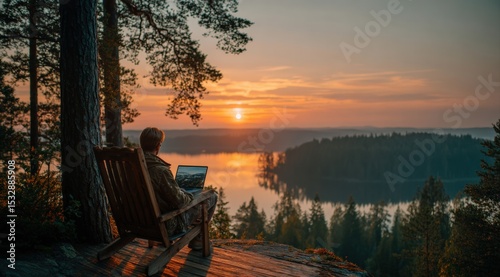 Young professional using laptop at sunset in Finland, enjoying freedom and stunning view of lake and forest