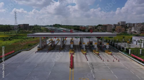 Approaching toll booths near Zhanjiang Wuchuan Airport in Guangdong China on a sunny day showing infrastructure and vehicles