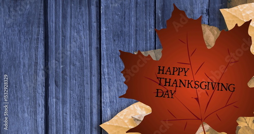Featuring large brownish-red maple leaf bearing HAPPY THANKSGIVING DAY on blue planks, copy space