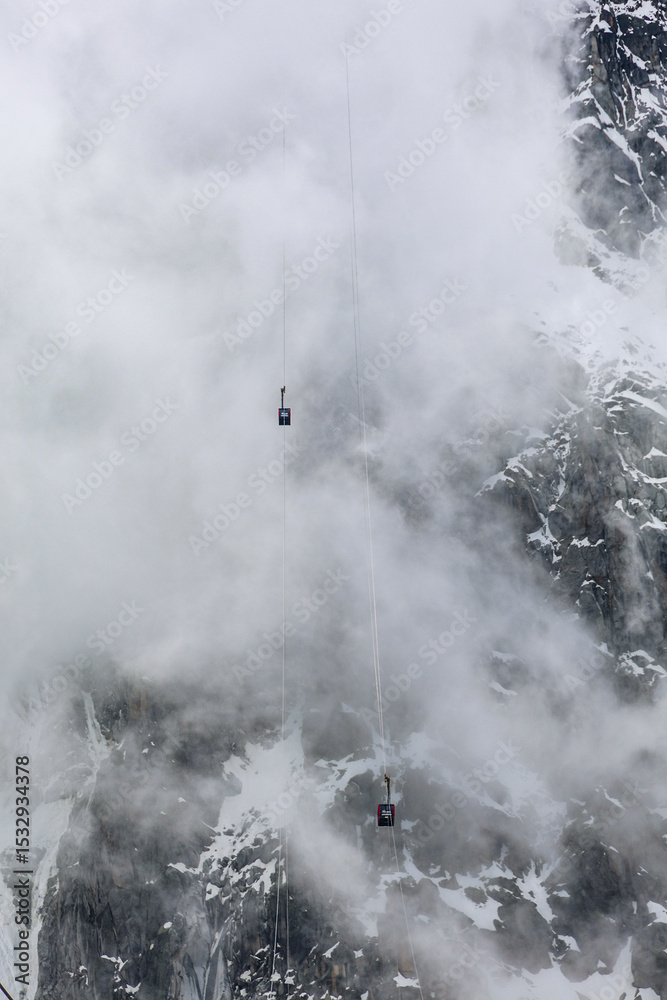 Fototapeta premium Cable car of Aiguille du Midi against the stormy clouds, Chamonix, Mont Blanc, France, Europe