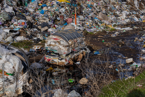 Piles of plastic and garbage fill a landfill area, showcasing the ongoing struggle with pollution and environmental impact on ecology
