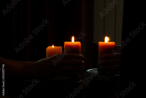 Canvas Print Female hand holding candle near mirror in dark room