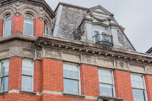 Victorian Gothic close-up, distinguished by its bold orange color and elaborate architectural ornaments.