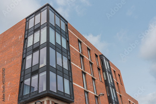 Residential steel structure featuring concrete, brickwork, and large windows.