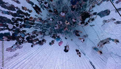 Group of people walking on mirrored ceiling with led lights display, crowd of people from above
