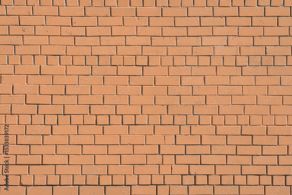 Fototapeta premium Brick wall constructed with uniform clay bricks arranged in a pattern showcasing a warm orange hue and solid structure in daylight