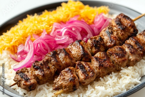 Succulent chelo kabab bakhtiari with mixed chicken and lamb skewers served over fragrant rice and garnished with pink pickled onion