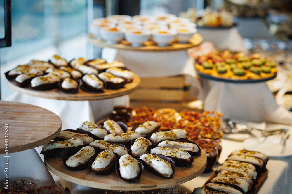 Fototapeta premium Assorted éclairs covered in chocolate on a festive table