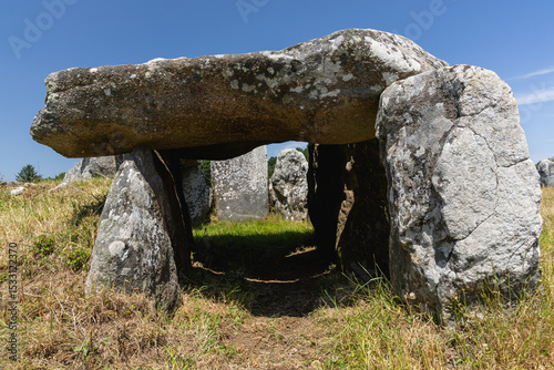 Un dolmen dans les alignements de Carnac sous un ciel bleu.
