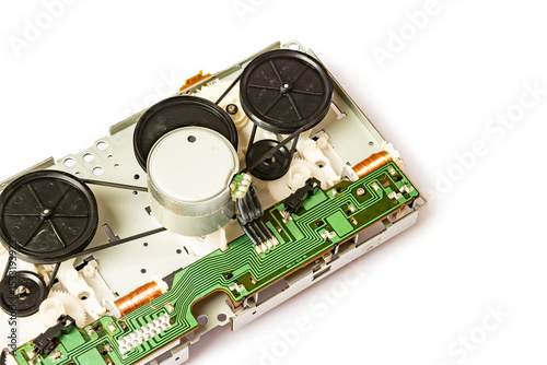 Close-up of the magnetic tape drive mechanism of an old double-cassette tape recorder on a white background. Close-up of the magnetic tape drive mechanism. Copy space