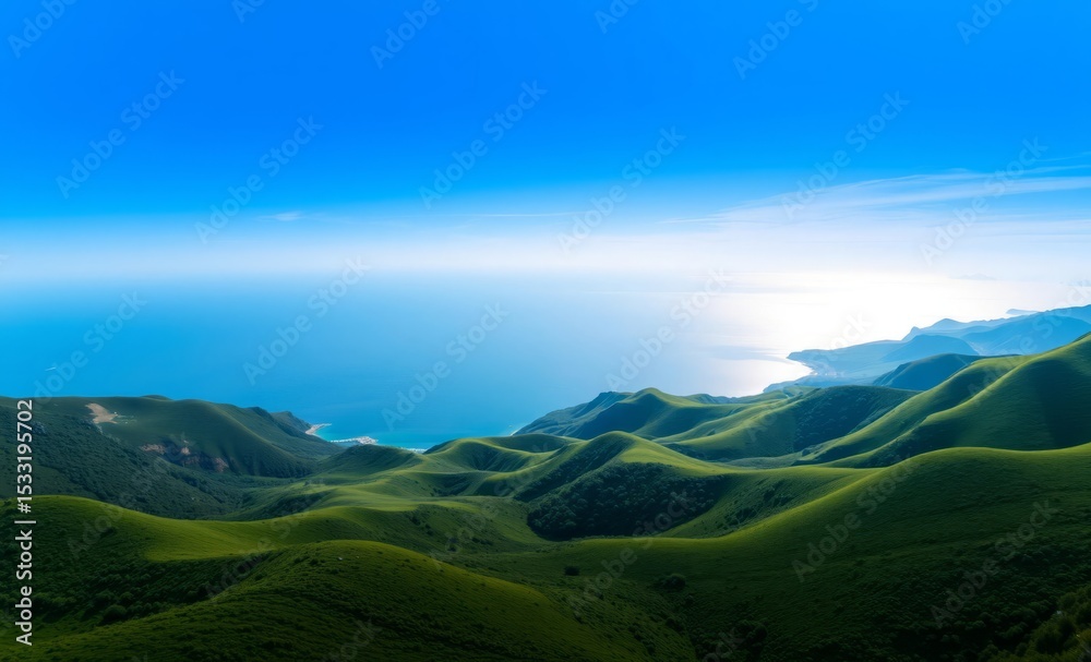 Obraz premium A breathtaking 4K aerial panorama reveals a tranquil coastal landscape where rolling green hills gracefully descend towards a serene blue expanse of water The horizon is dotted with distant sailboa