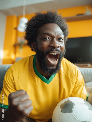 Brazilian football fan shouting during win indoors wearing yellow jersey