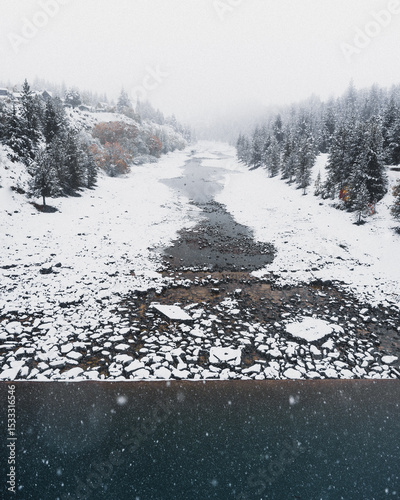Snow covered rocks on the side of a river in New Zealand.