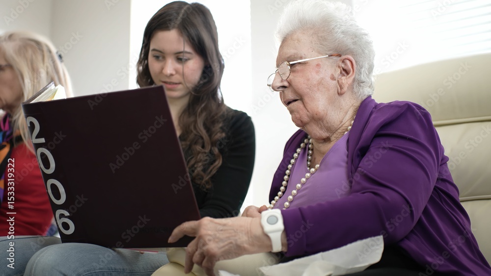 Fototapeta premium Grandmother and granddaughter enjoy a special moment looking through a family album, reflecting on cherished memories and strengthening their bond.