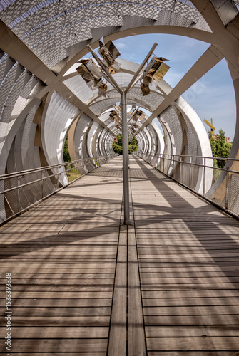 Madrid, Spain - June 1, 2025: The Arganzuela Footbridge in the Parque Madrid Rio along the Rio Manzanares in Madrid in Spain
