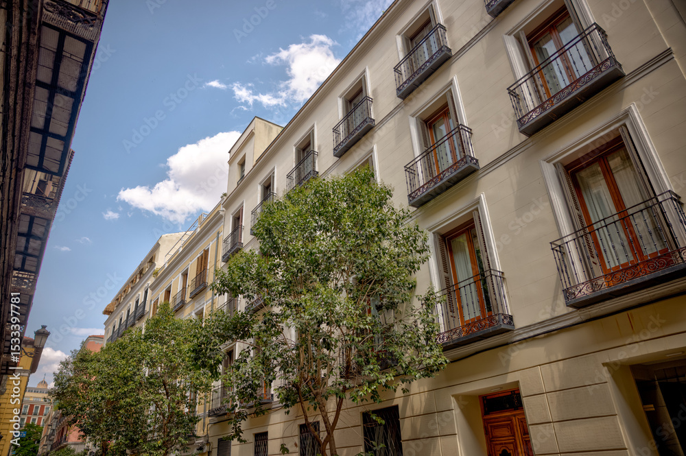 Fototapeta premium Madrid, Spain - June 1, 2025: Buildings and pedestrians along the streets in Madrid in Spain 