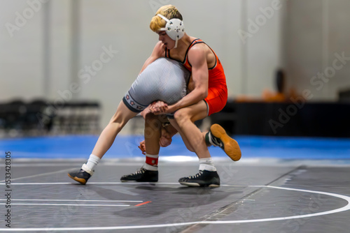 High School Wrestling Match Action – Takedown in Progress on Mat

