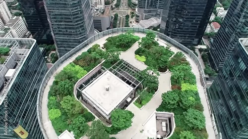 Aerial View of Modern Skyscraper Rooftop Garden Surrounded by Tall Office Buildings