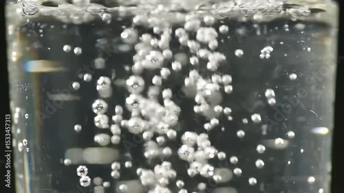 Closeup of Water Bubbles Forming and Rising in Clear Liquid with Dynamic Movement and Light Reflections