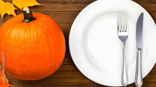 Two plates, one empty and one with an orange pumpkin and fork, are set on a table, evoking a festive autumn harvest meal