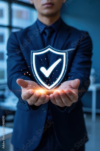 Businessperson holding a glowing shield symbol.