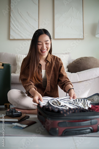 Female traveler organizing essentials in her luggage before leaving for a vacation.