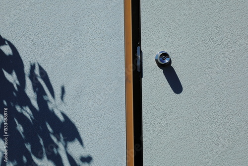 長野県諏訪市霧ヶ峰のプレハブ小屋のドアと葉っぱの影