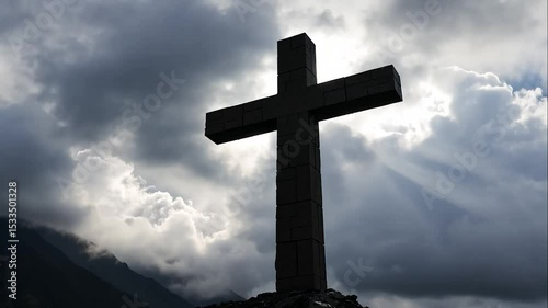 Stone cross silhouetted against a dramatic cloudscape revealing divine light