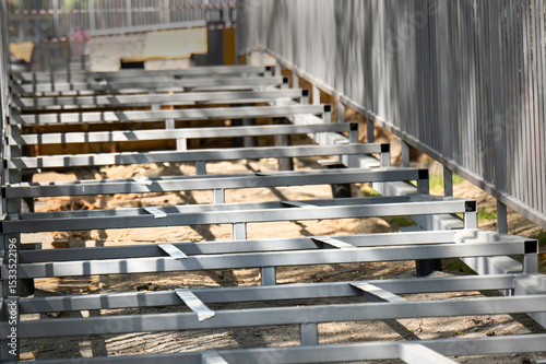 Base of a metal staircase made from square profile tubes with railings, showcasing industrial construction and design