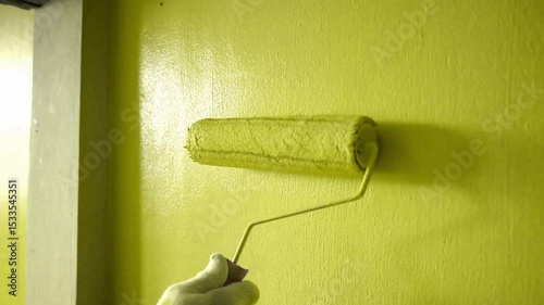 paint roller on a yellow wall