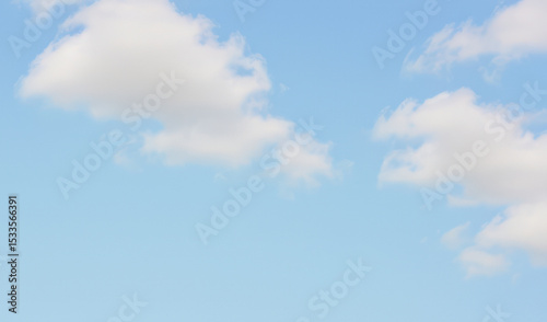 Blue sky with fluffy white clouds on a sunny day.