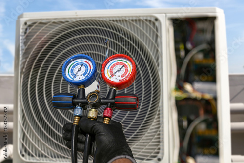 Electrical technician use manifold gauge check and filling refrigerant vacuum pump evacuates industry air conditioning HAVC system maintenance or chiller and air conditioner cleaning filter service.