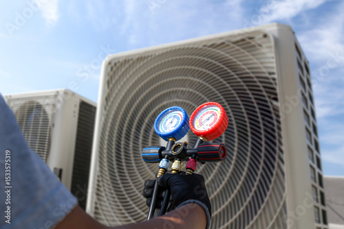 Electrical technician use manifold gauge check and filling refrigerant vacuum pump evacuates industry air conditioning HAVC system maintenance or chiller and air conditioner cleaning filter service.