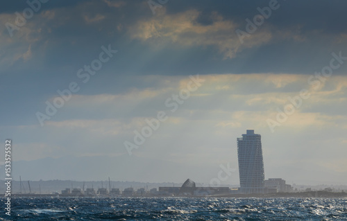 Stormy sea infont of Ayia Napa silhouette under overcast sky with godrays.