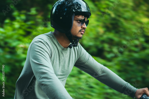 Closeup of young guy enjoying motorbike ride in the forest.