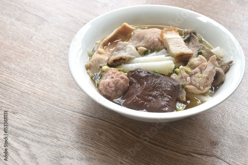 large rice noodles chop and crispy pork topping blood in clear soup on bowl   