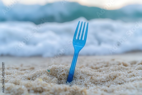 Plastic fork discarded on a sandy beach.
