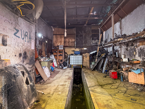 Fototapeta Naklejka Na Ścianę i Meble -  An auto mechanic workshop packed with tools, wires, and metal parts shows real industrial grit and functional chaos.